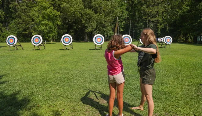 counselor teaching archery