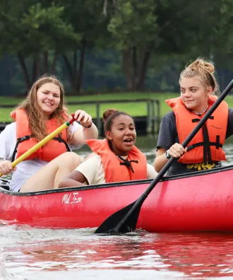 Three girls in a canoe at Day Camp