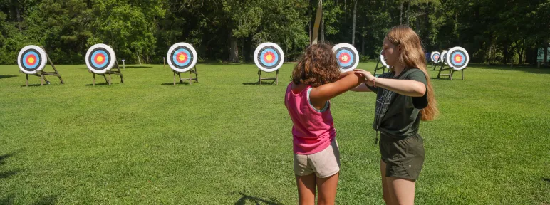 counselor teaching archery