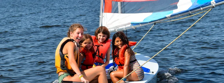 Three campers and a counselor on a sailboat