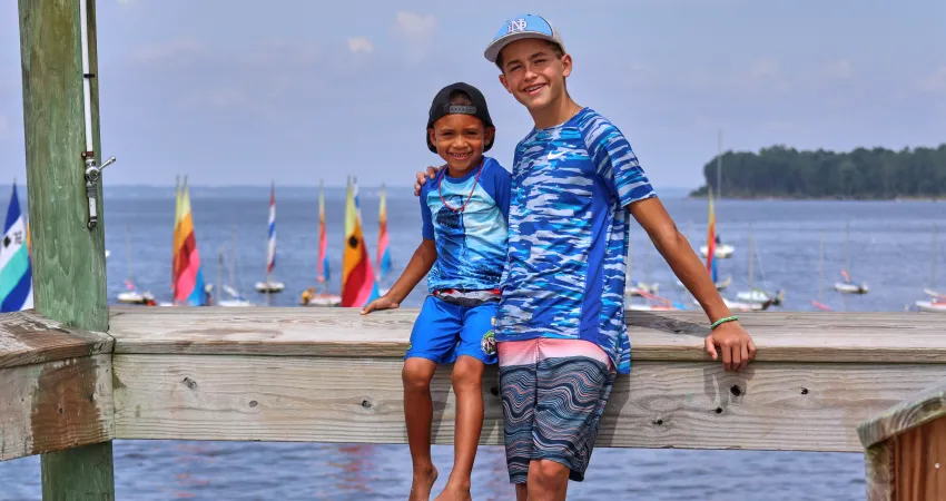 Camper and CILT counselor sitting on the dock at day camp