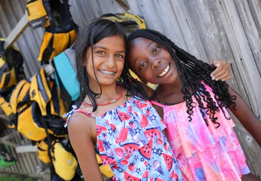 Two girls near the lifejacket rack for camp